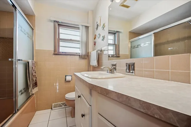 a bathroom with a sink a toilet a mirror and shower