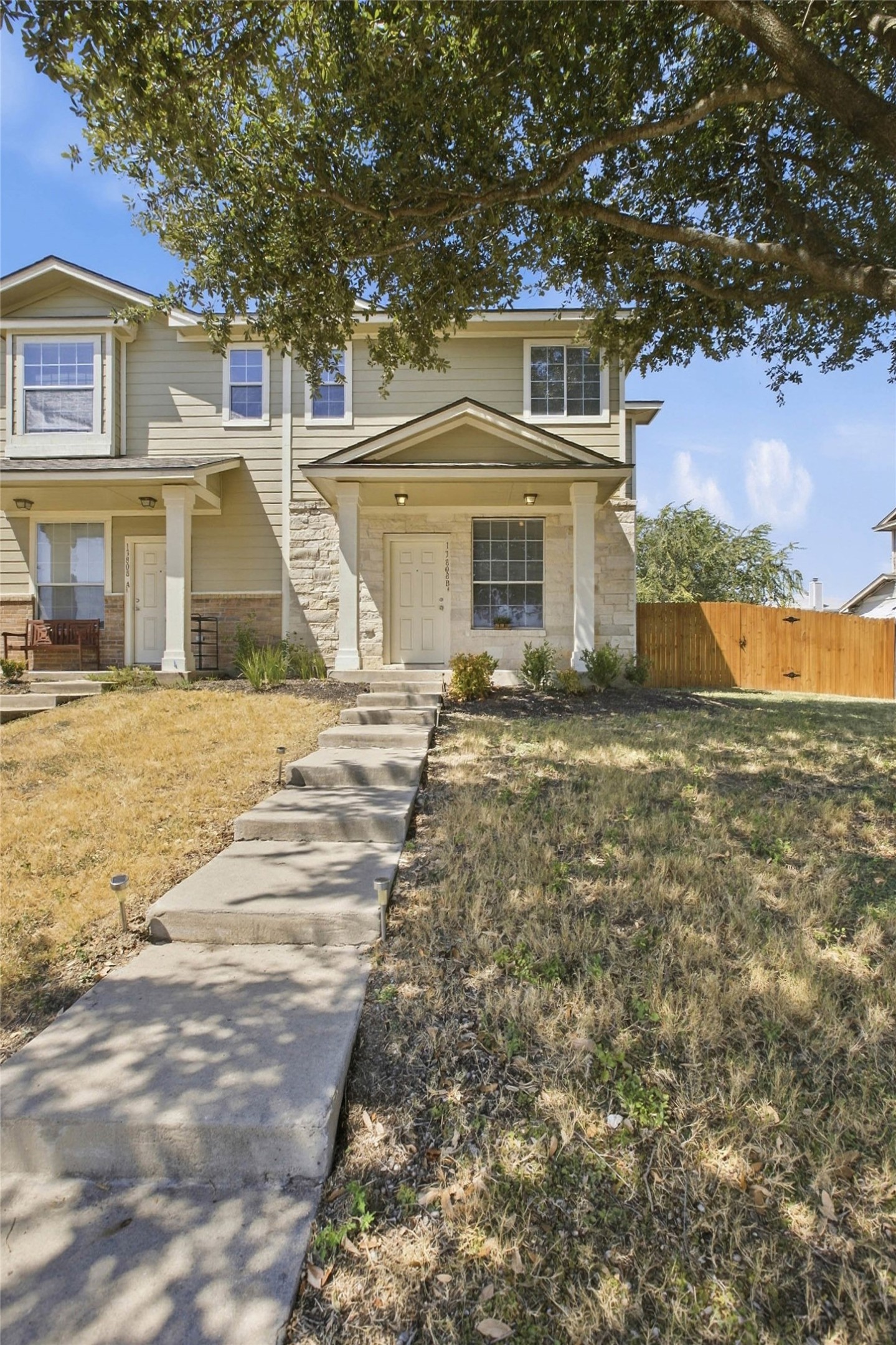 13808 Harris Ridge Boulevard, Unit B Pflugerville, TX 78660 - Photo 5 of 33 A concrete walkway leads past mature shade trees to a welcoming covered front porch.