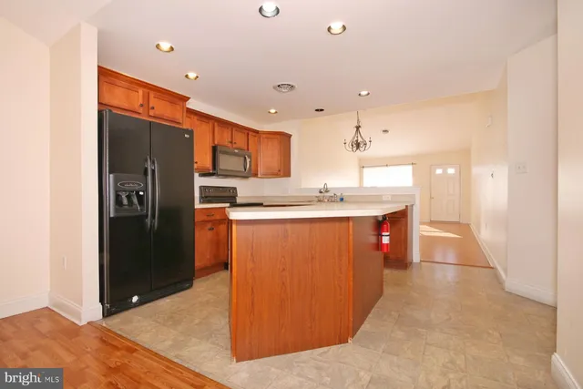 a kitchen with stainless steel appliances granite countertop a refrigerator a sink and a stove