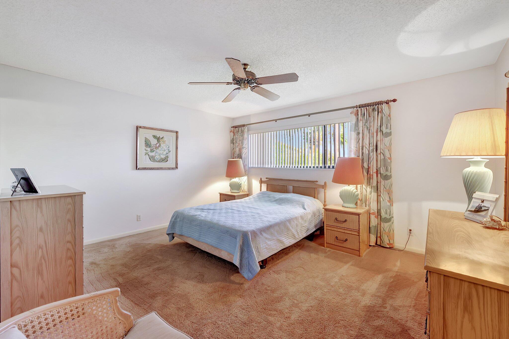 3001 Southeast Aster Lane, Unit 906 Stuart, FL 34994 - Photo 14 of 24 a bedroom with a bed and a lamp on table