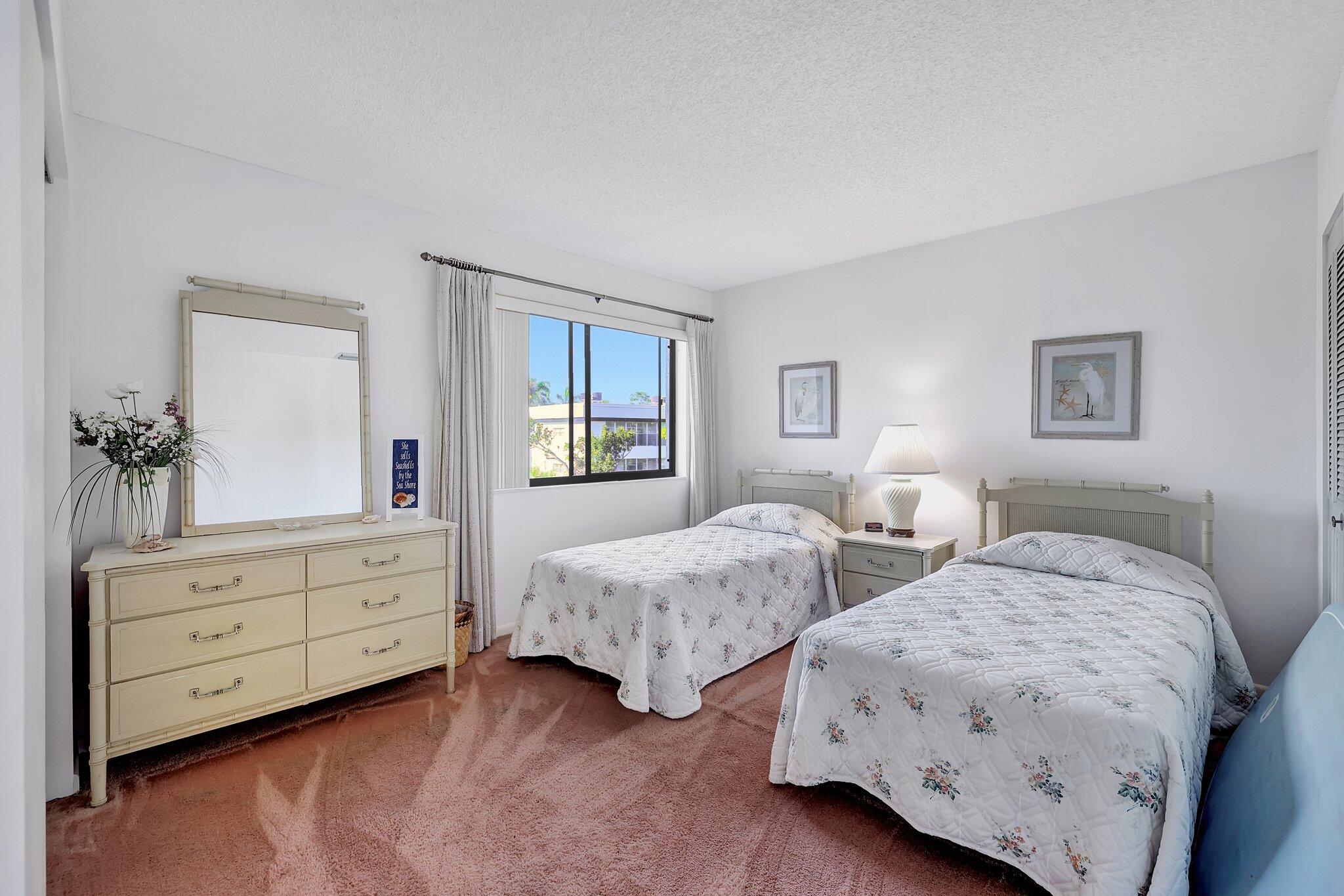 3001 Southeast Aster Lane, Unit 906 Stuart, FL 34994 - Photo 20 of 24 a bedroom with two beds and a dresser
