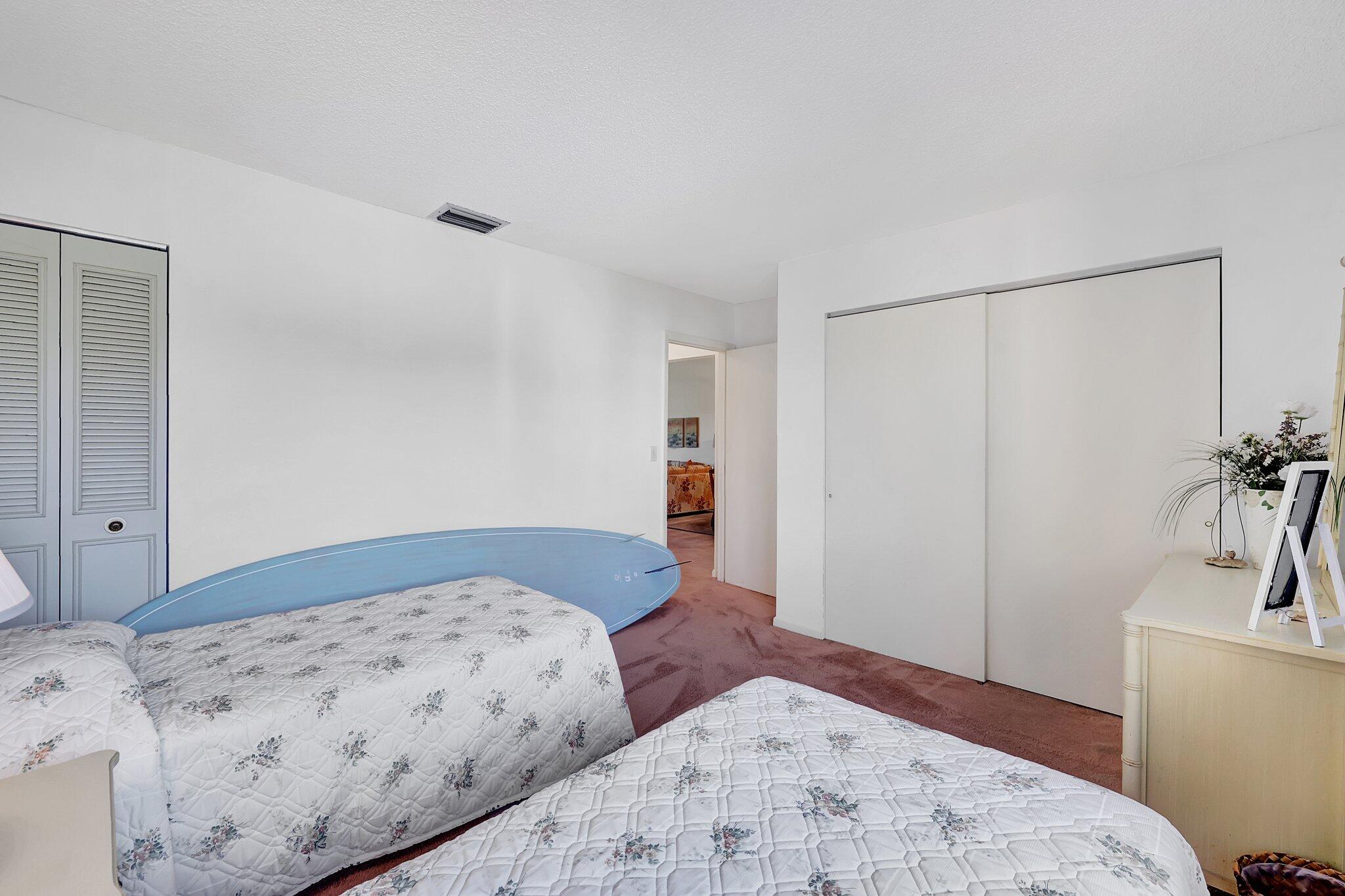 3001 Southeast Aster Lane, Unit 906 Stuart, FL 34994 - Photo 21 of 24 a bedroom with a bed and a view of bathroom