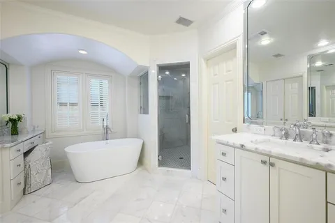 a spacious bathroom with a tub sink and mirror
