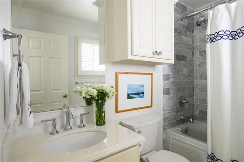 a bathroom with a granite countertop sink a toilet and shower