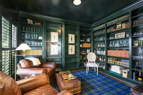 a living room with furniture a rug and a floor to ceiling window