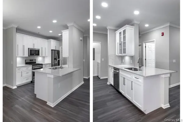 a large kitchen with stainless steel appliances a stove top oven a sink dishwasher and white cabinets with wooden floor