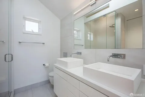 a bathroom with a sink a toilet and mirror