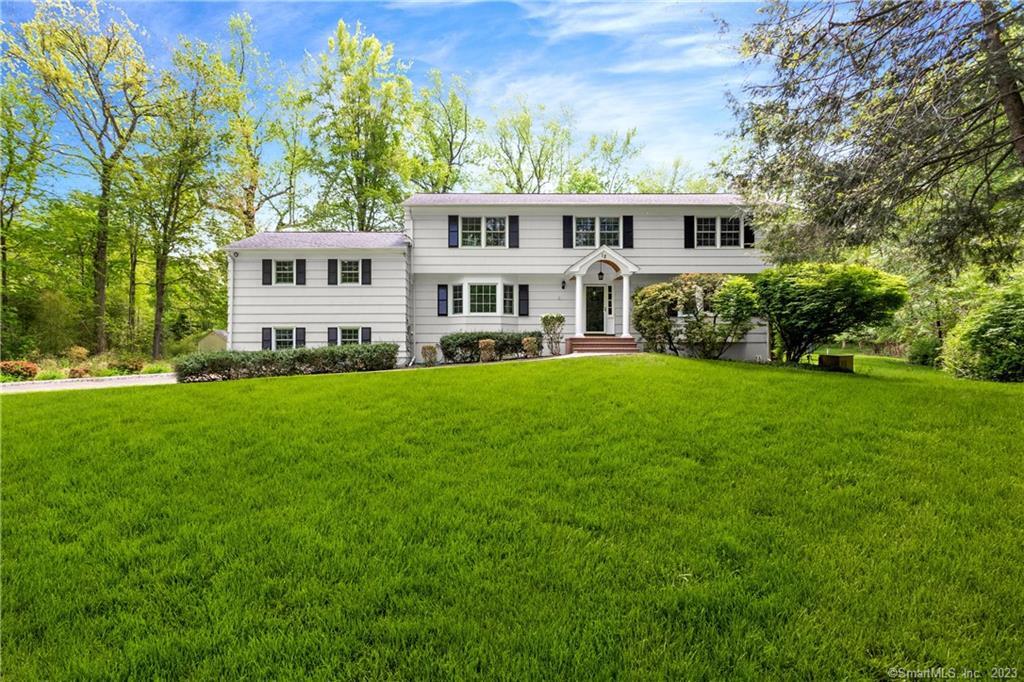 a front view of a house with a yard table and trees