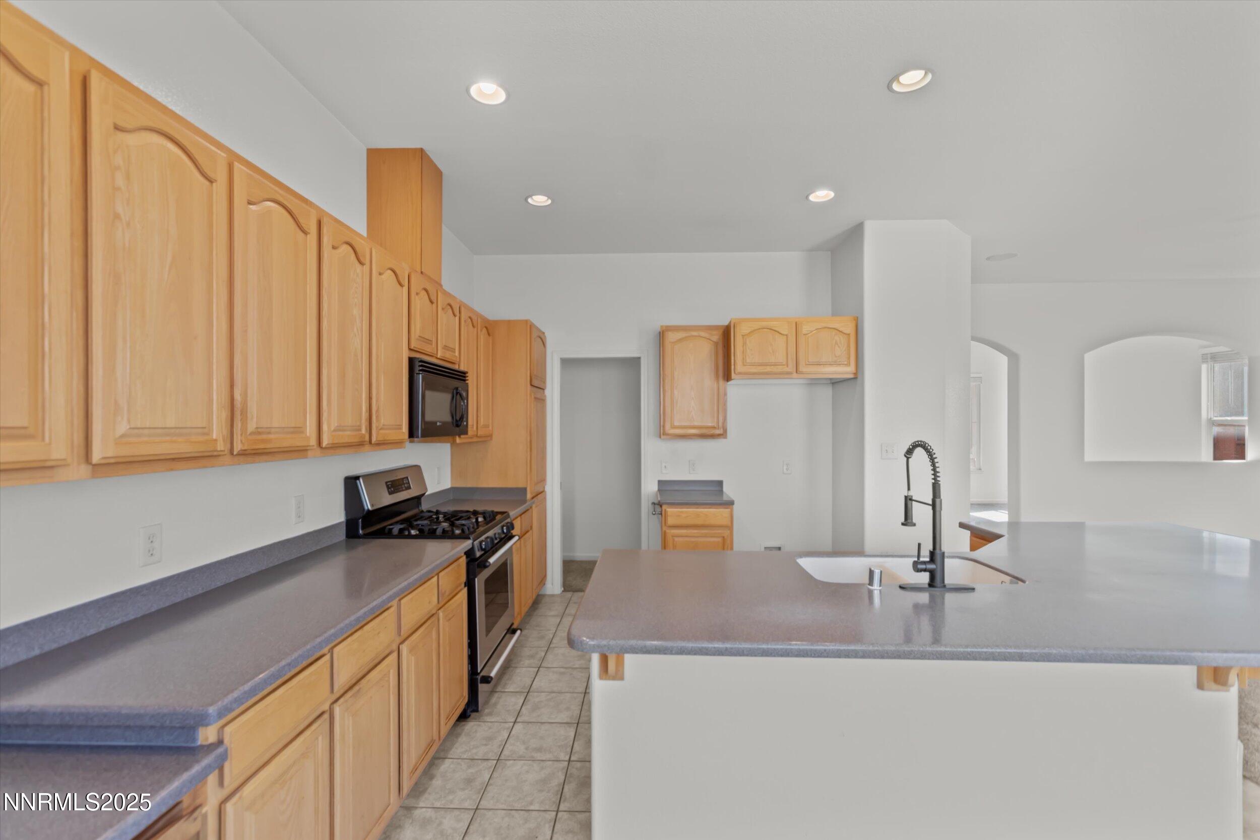 2365 Red Maple Court Reno, NV 89523 - Photo 12 of 34 a kitchen with kitchen island granite countertop a sink a counter top space appliances and cabinets