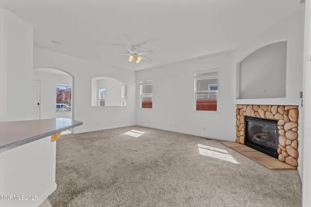 an empty room with windows and fireplace