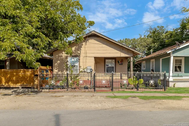 a front view of house with yard and trees in the background