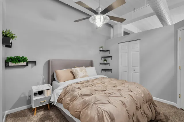 a bedroom with a bed and a ceiling fan