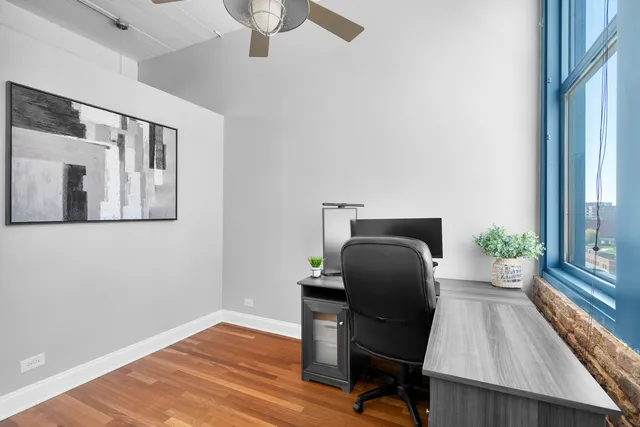 a view of a workspace with furniture and a window