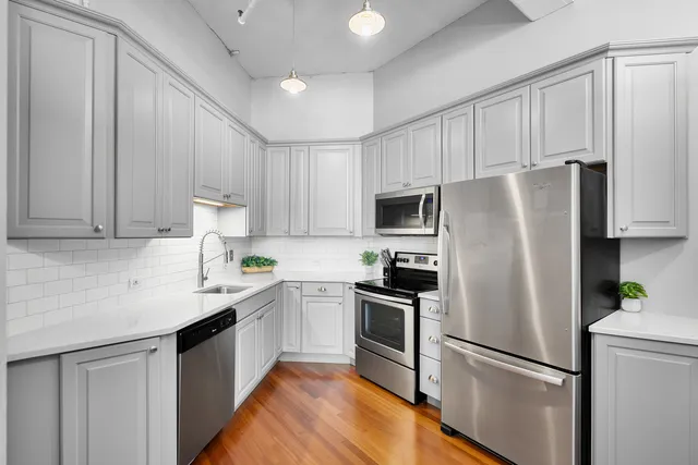 a kitchen with stainless steel appliances a refrigerator sink and microwave