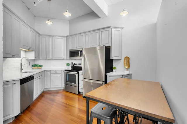 a kitchen with stainless steel appliances granite countertop a refrigerator sink and stove