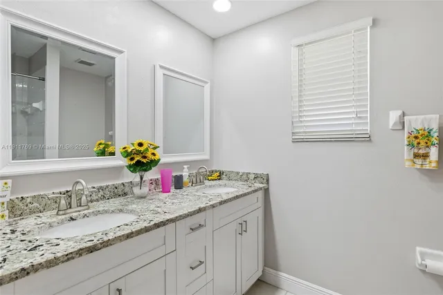 a bathroom with a granite countertop sink and a mirror