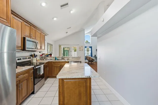 a kitchen with stainless steel appliances granite countertop a refrigerator a stove top oven a sink dishwasher and granite countertops with cabinets