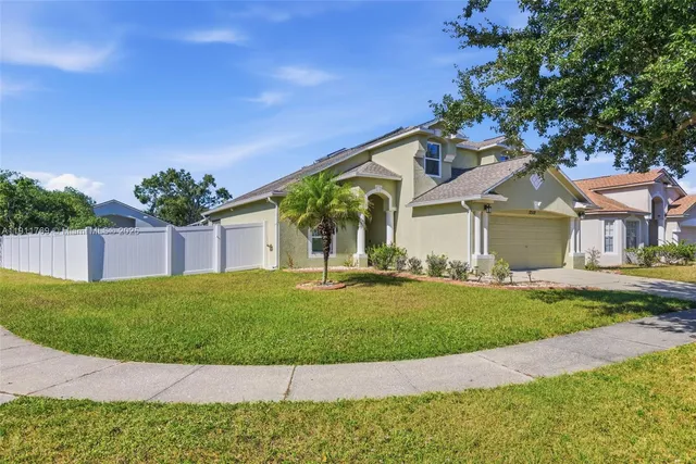a front view of a house with a garden and yard