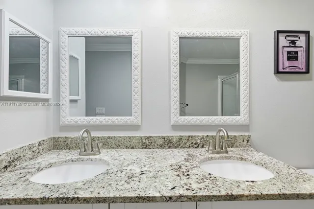 a bathroom with a granite countertop sink and a mirror