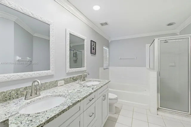 a bathroom with a granite countertop sink a toilet and shower