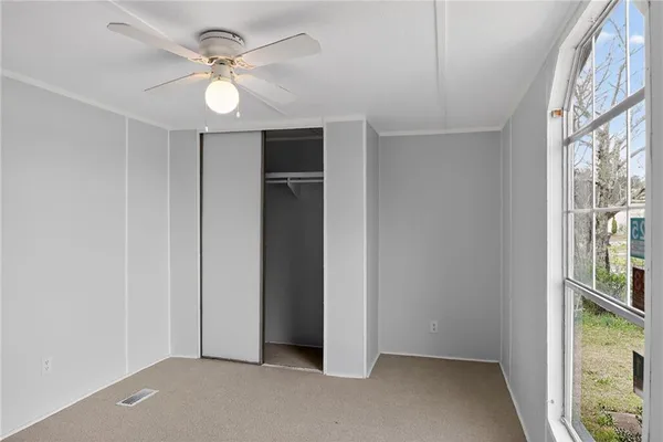 an empty room with windows and fan