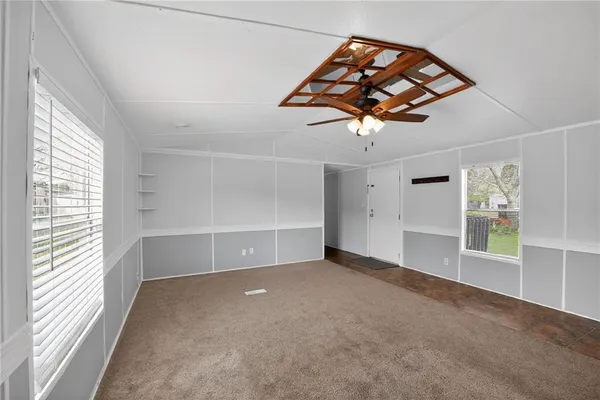 an empty room with windows and cabinet