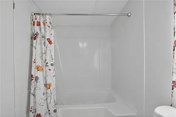 a bathroom with a shower and a curtain