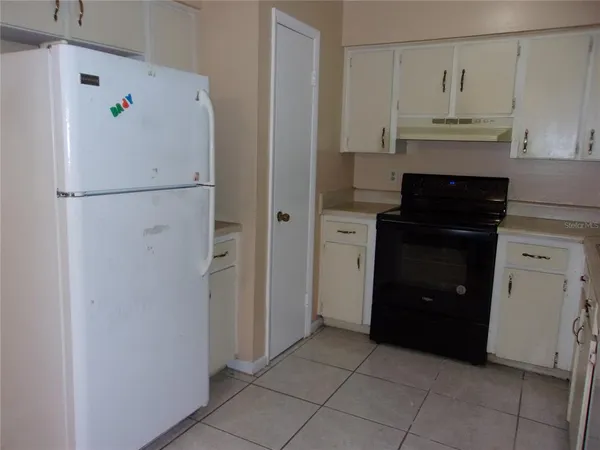 a kitchen with a refrigerator and a stove