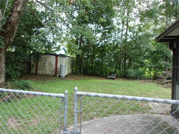 a view of backyard with table and chairs and plants