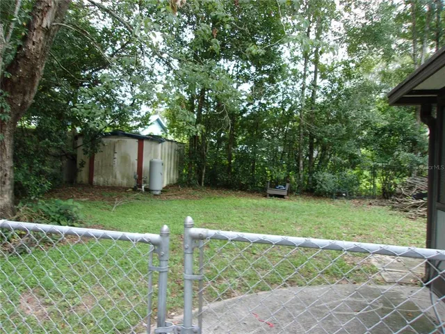 a view of backyard with table and chairs and plants
