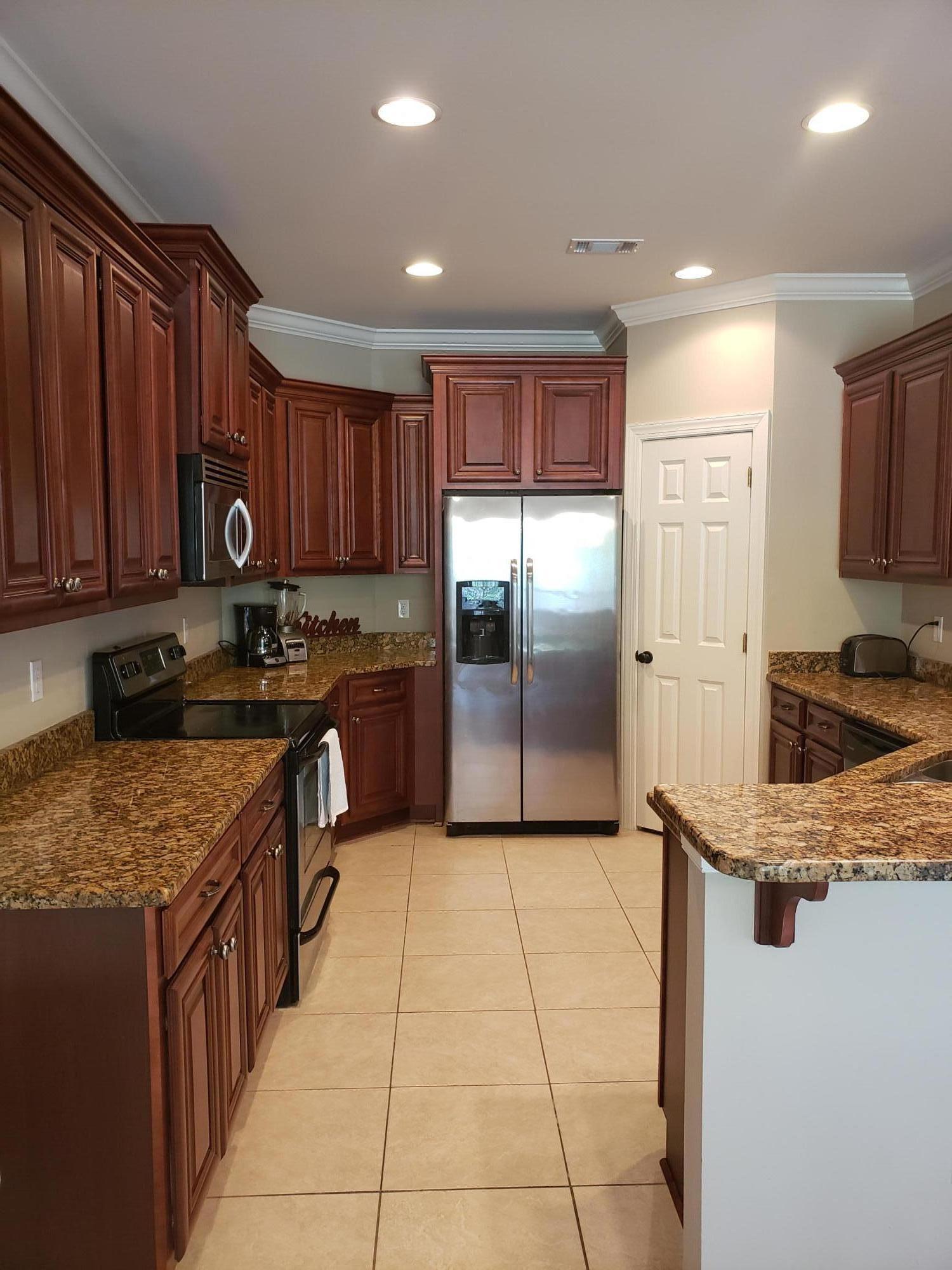 456 Windchime Way Freeport, FL 32439 - Photo 5 of 29 a kitchen with stainless steel appliances granite countertop a stove a refrigerator and a sink