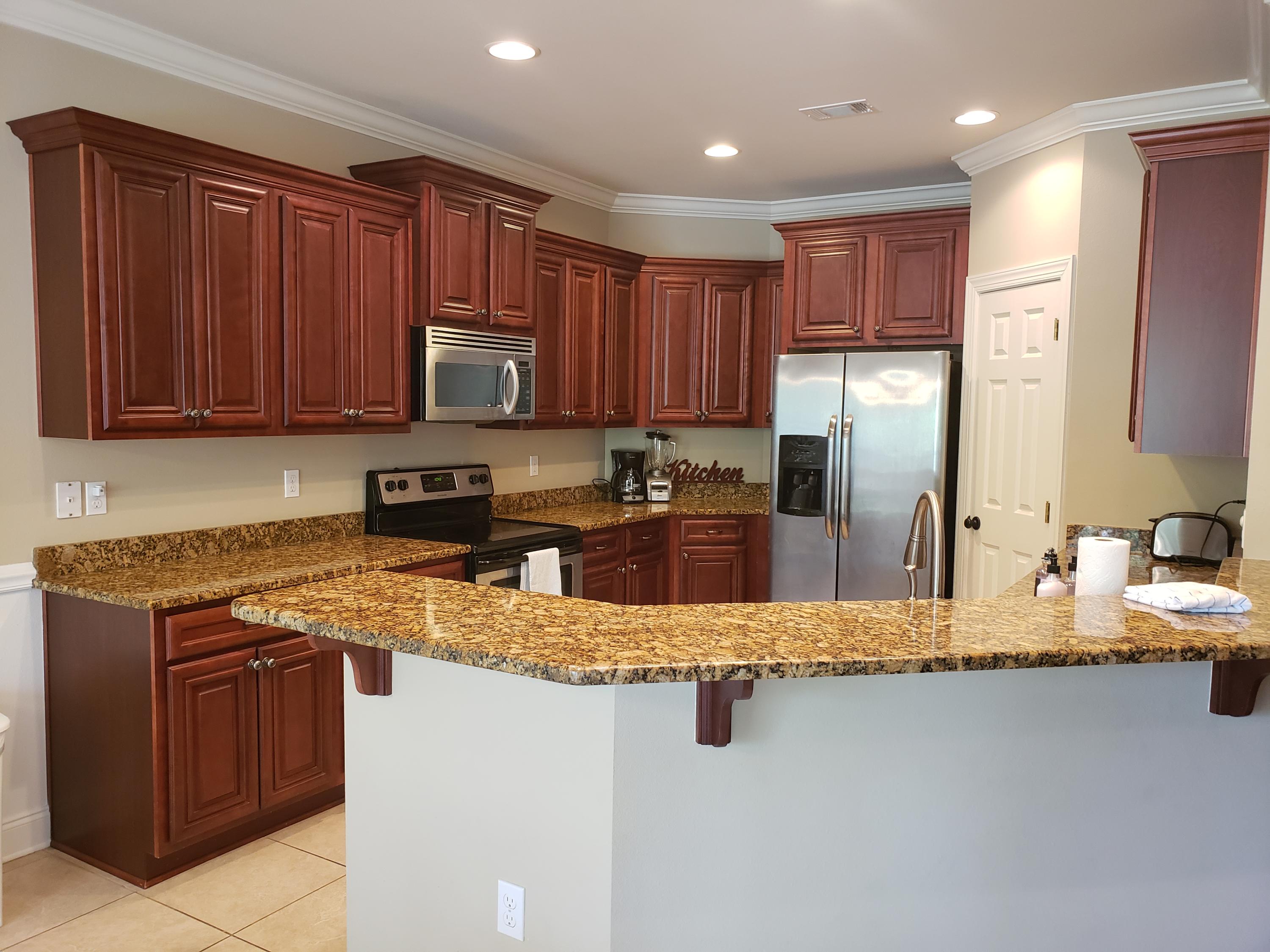 456 Windchime Way Freeport, FL 32439 - Photo 6 of 29 a kitchen with stainless steel appliances granite countertop a stove a sink and a refrigerator