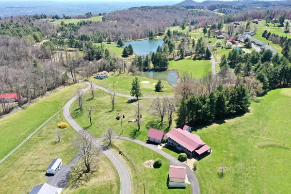 an aerial view of a house with a garden and lake view
