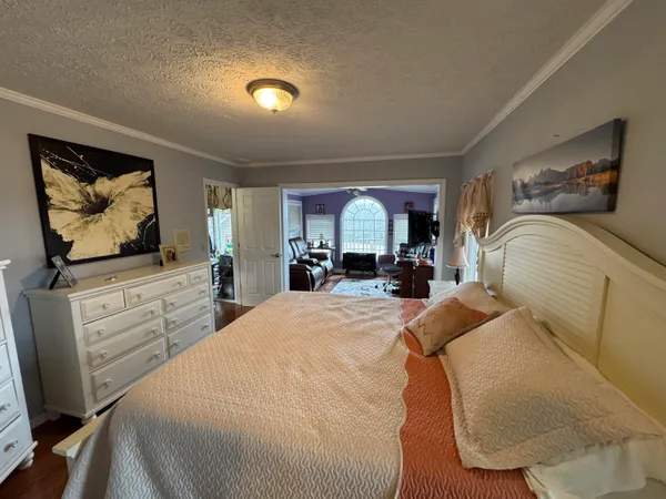a living room with furniture a flat screen tv and kitchen view