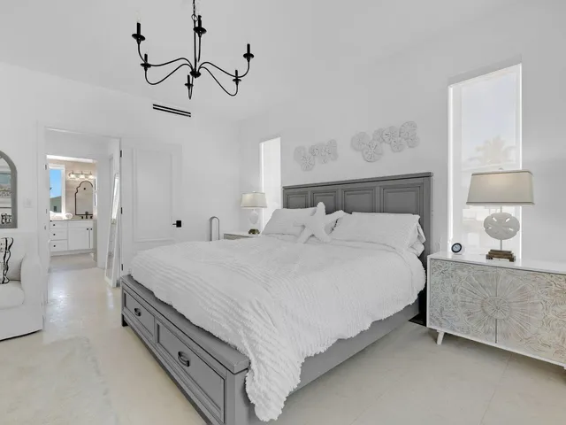 a spacious bedroom with a bed and a lamp