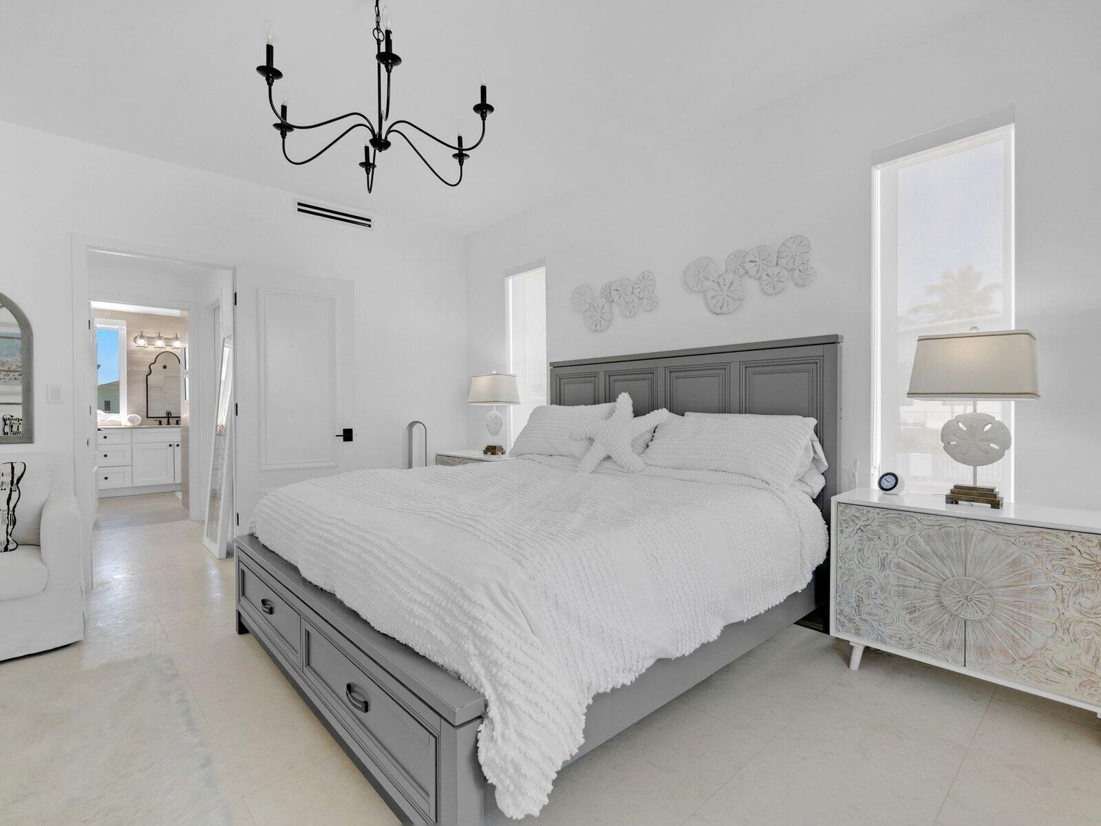 317 East Seaview Circle Marathon, FL 33050 - Photo 24 of 52 a spacious bedroom with a bed and a lamp