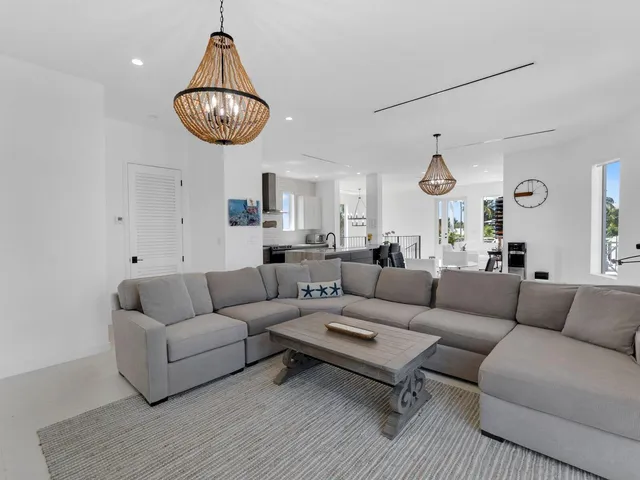 a living room with furniture a rug and white walls