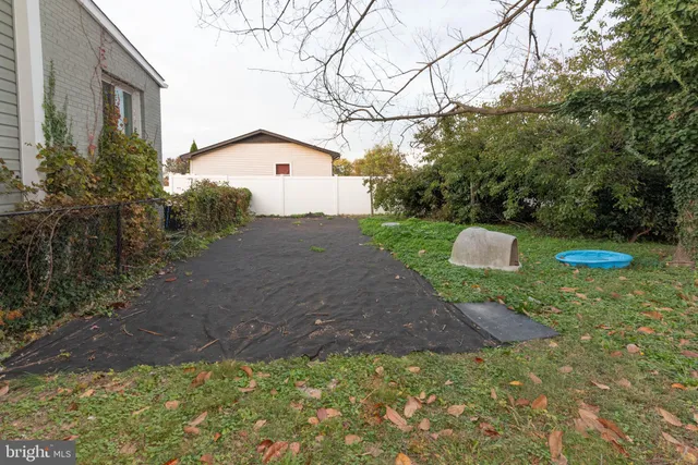 a backyard of a house with a tree and fence