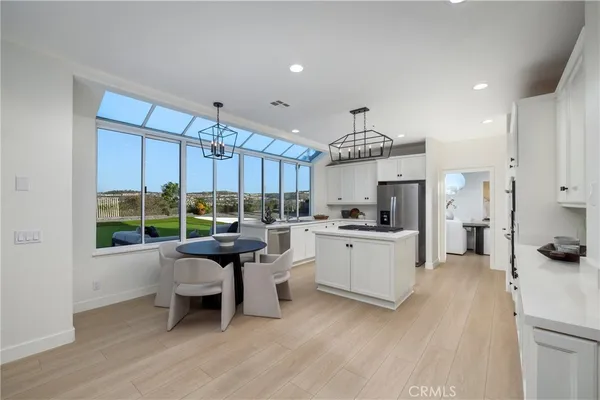 a kitchen with kitchen island a large counter top space a sink stainless steel appliances and cabinets