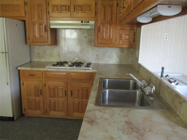 a white refrigerator freezer and a stove sitting inside of a kitchen