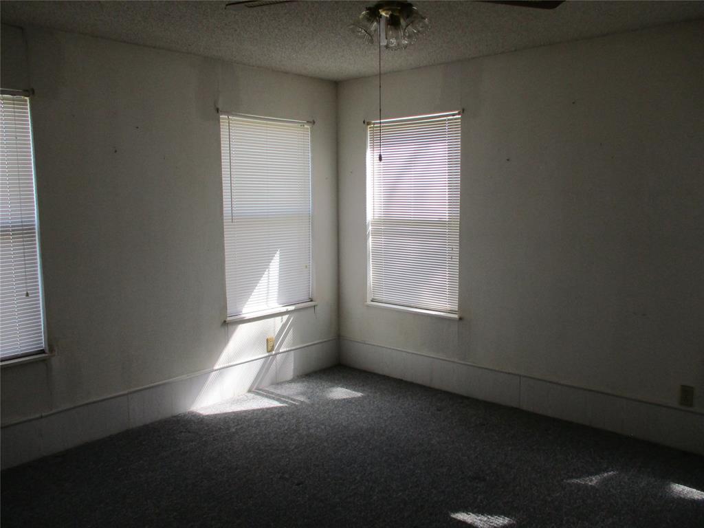 310 County Road 1495 Emory, TX 75440 - Photo 20 of 24 en empty room with windows and chandelier fan