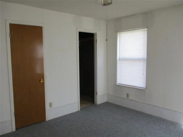 an empty room with windows and cabinet