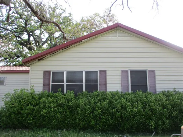 a front view of a house with plants and garden