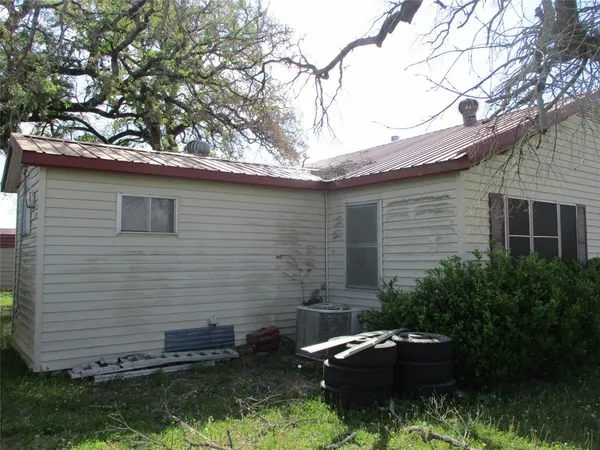 a backyard of a house with yard fire pit and tree