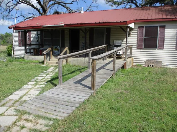 a view of house with backyard and furniture