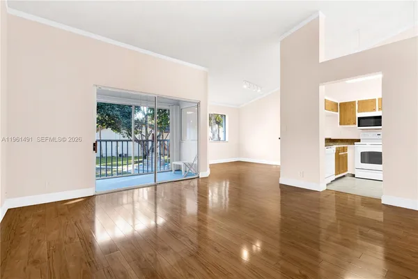 a view of a big room with wooden floor and windows
