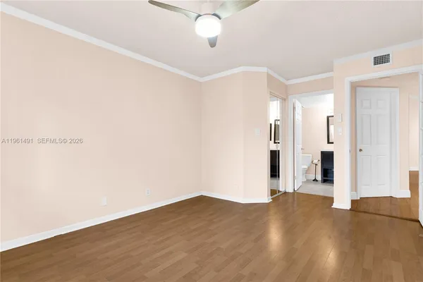 a view of an empty room with wooden floor