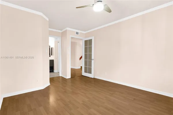 an empty room with wooden floor and windows