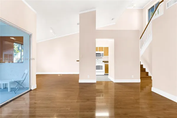 a view of empty room with wooden floor