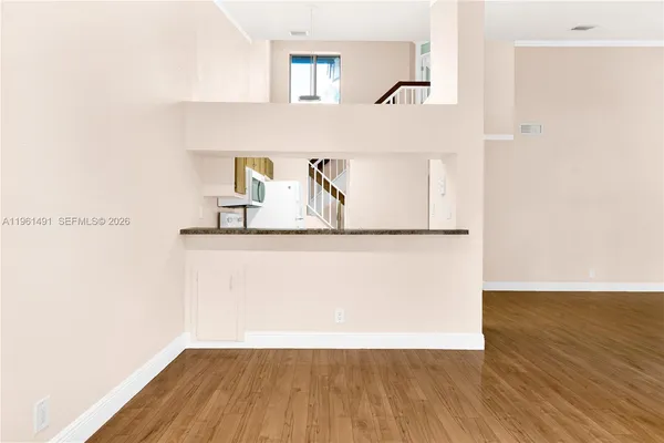 a view of empty room with wooden floor